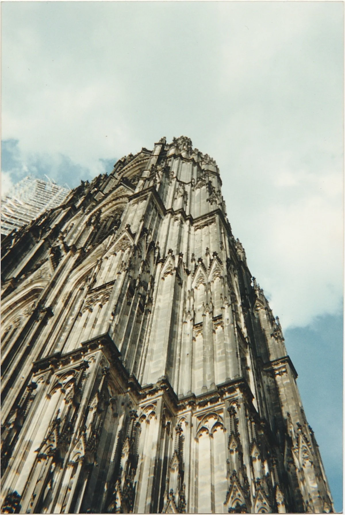 Dramatic upward perspective of a Gothic cathedral tower reaching into the sky.