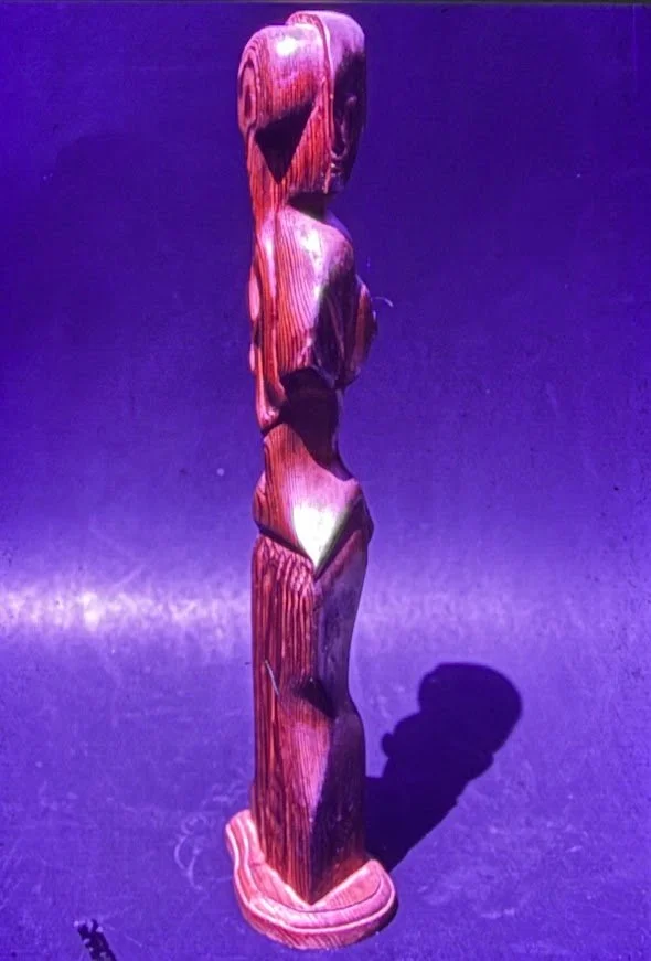 Tall vertical wood carving composed of stacked organic forms rising upward.