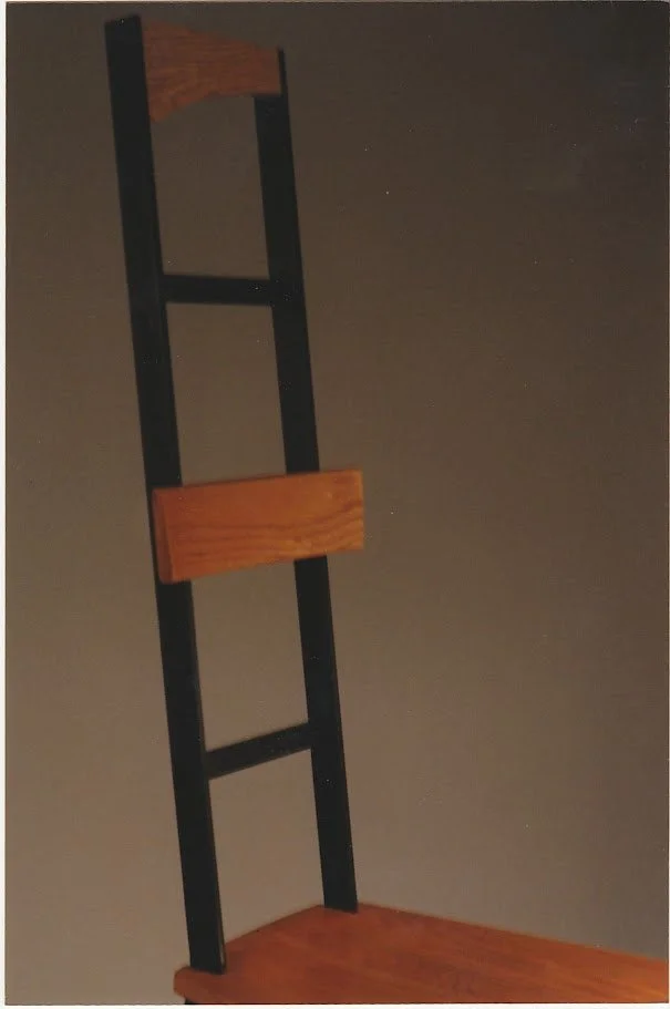 Close-up view of the upper ladder-back structure showing wood and black metal construction.