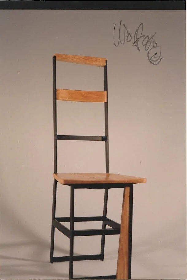 Front-facing chair with black metal frame and warm-toned wood components.
