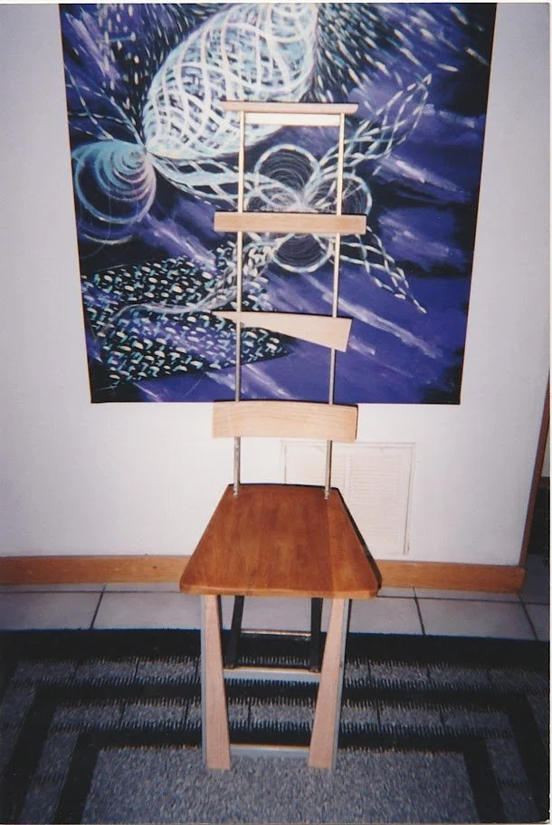 Chair displayed in front of a colorful wall hanging, emphasizing its sculptural silhouette.