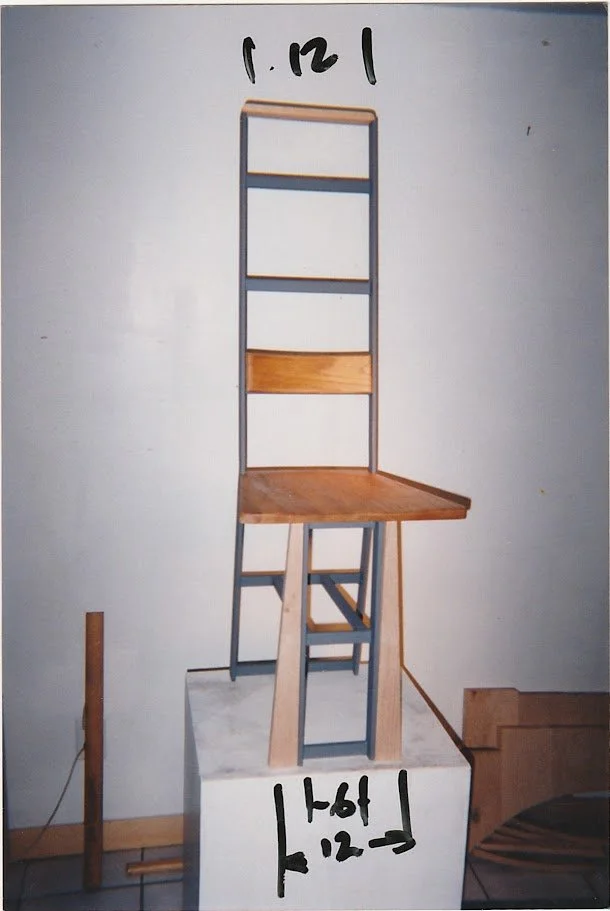 Measured chair prototype shown on a pedestal with handwritten width and height markings.
