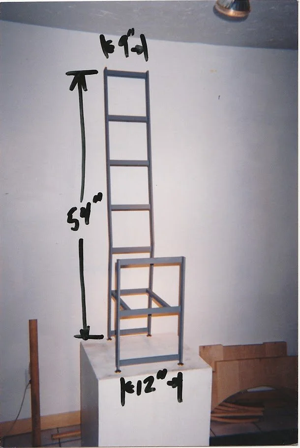 Chair prototype displayed with handwritten measurements indicating overall dimensions.