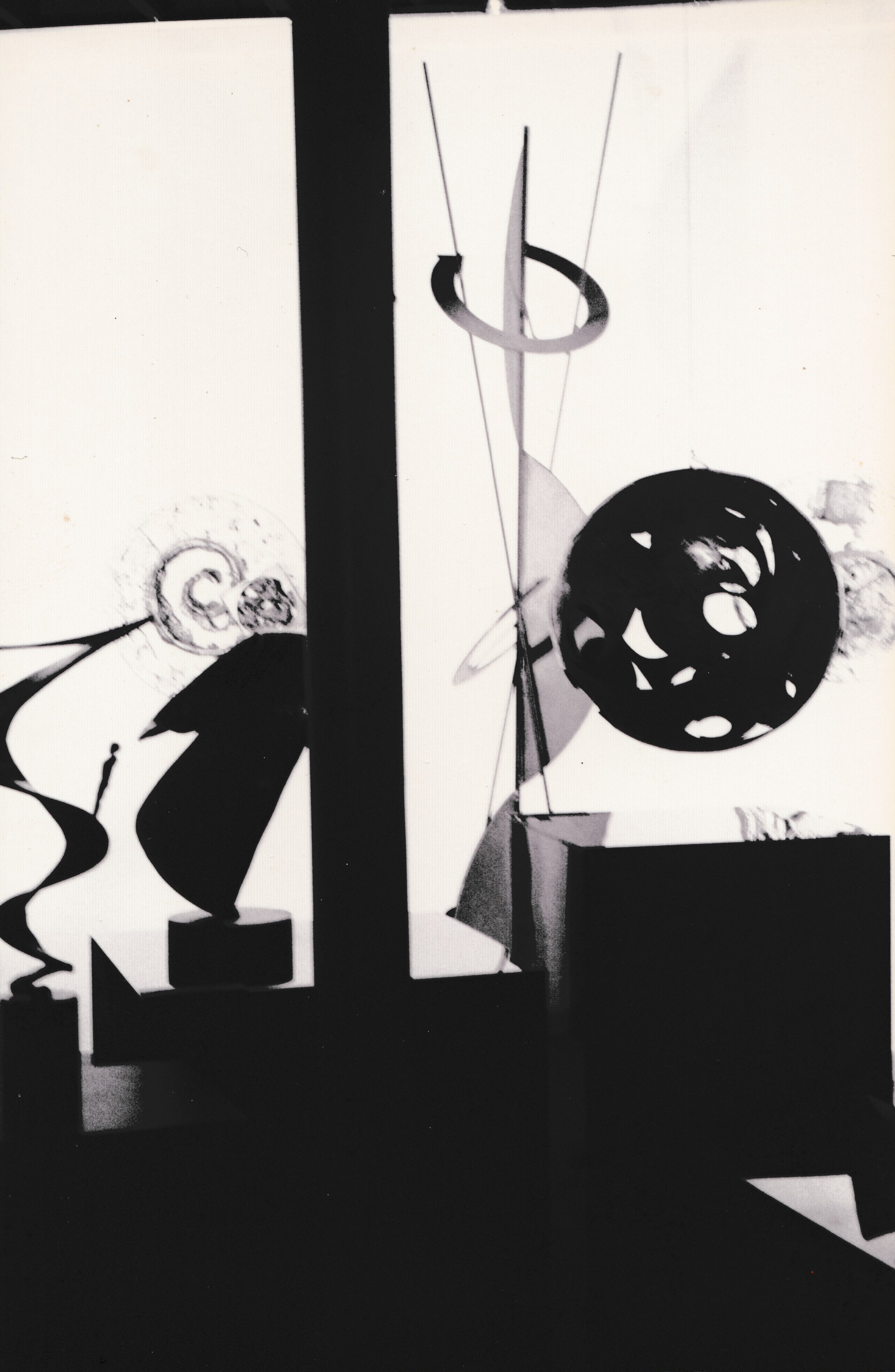 Abstract sculpture featuring a large circular disc balanced within a vertical linear framework.