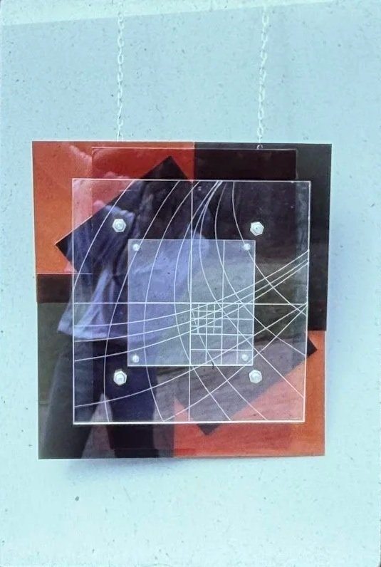 Layered mixed-media wall sculpture composed of transparent acrylic panels, geometric shapes, and intersecting grid patterns.