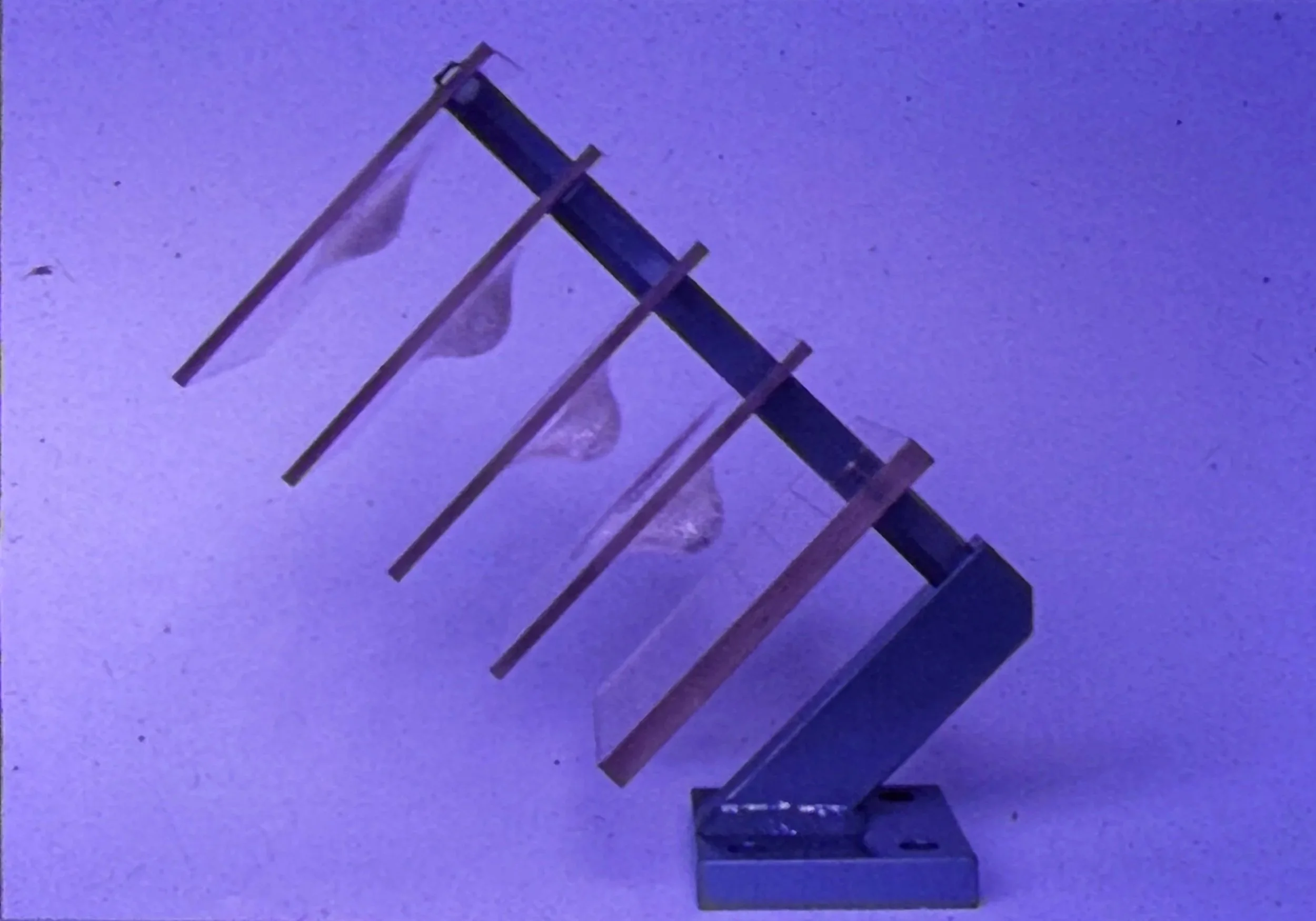 Geometric sculpture featuring a series of angled transparent panels arranged in a descending stepped formation.