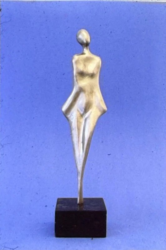 Stylized bronze female form balanced on a small pedestal, her body reduced to elegant geometric curves and angular planes.