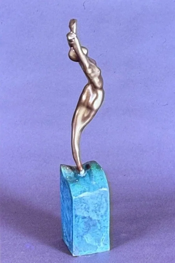 Graceful bronze dancer arching backward atop a turquoise stone base, one arm reaching high above the head.