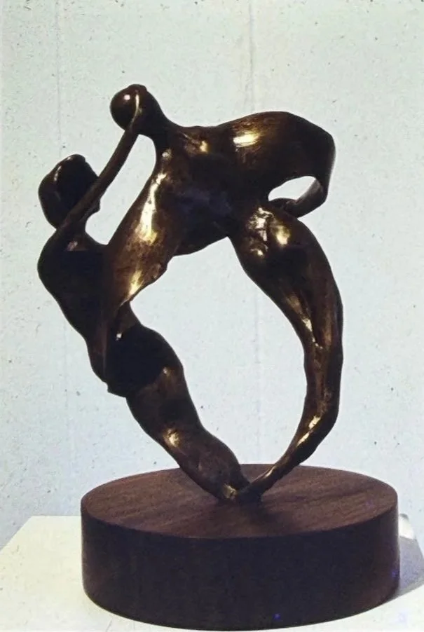 Interlocking abstract bronze sculpture composed of two entwined figures whose bodies merge into a continuous looping form.