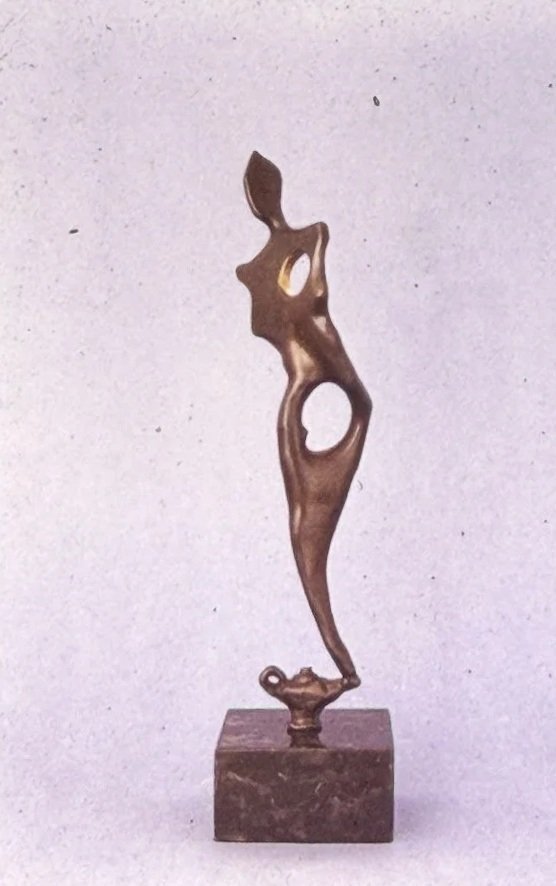 Openwork bronze sculpture of a female form reduced to flowing curves and negative space, with a large circular opening through the torso and a delicate, coming out of a genie's lamp.