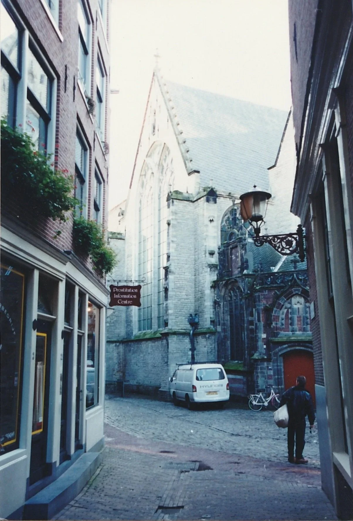 Narrow cobblestone alley opening toward a church façade at the end of the street.