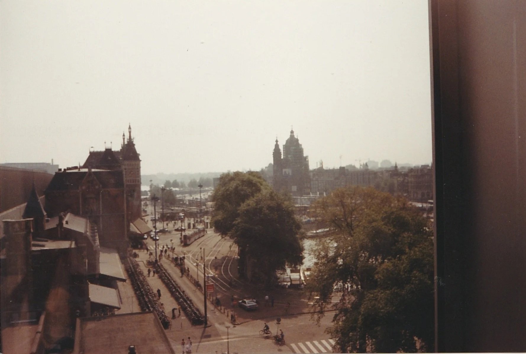 Elevated city view overlooking historic rooftops, streets, and distant church domes.