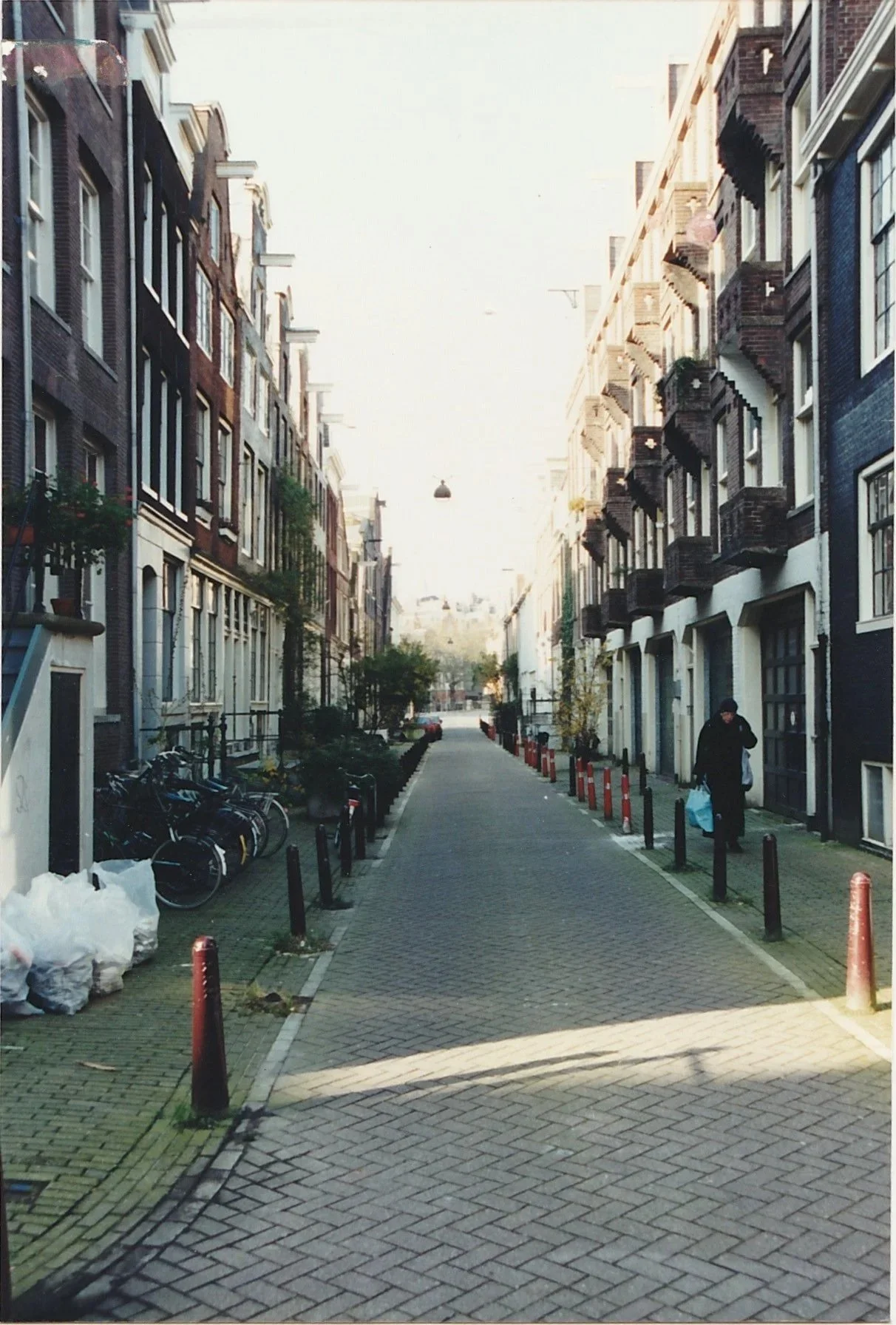Quiet brick-lined residential street stretching into the distance between rows of historic buildings.
