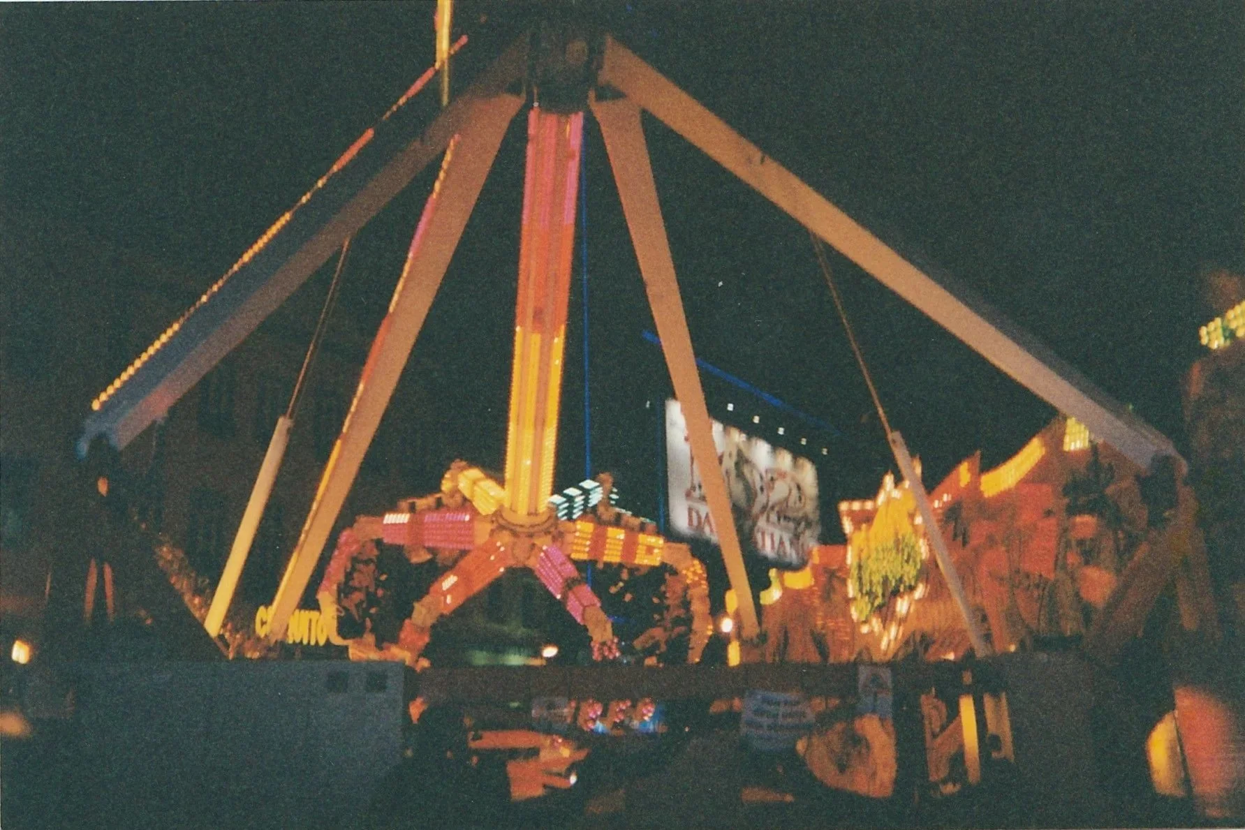 Brightly lit carnival ride glowing against the night sky.