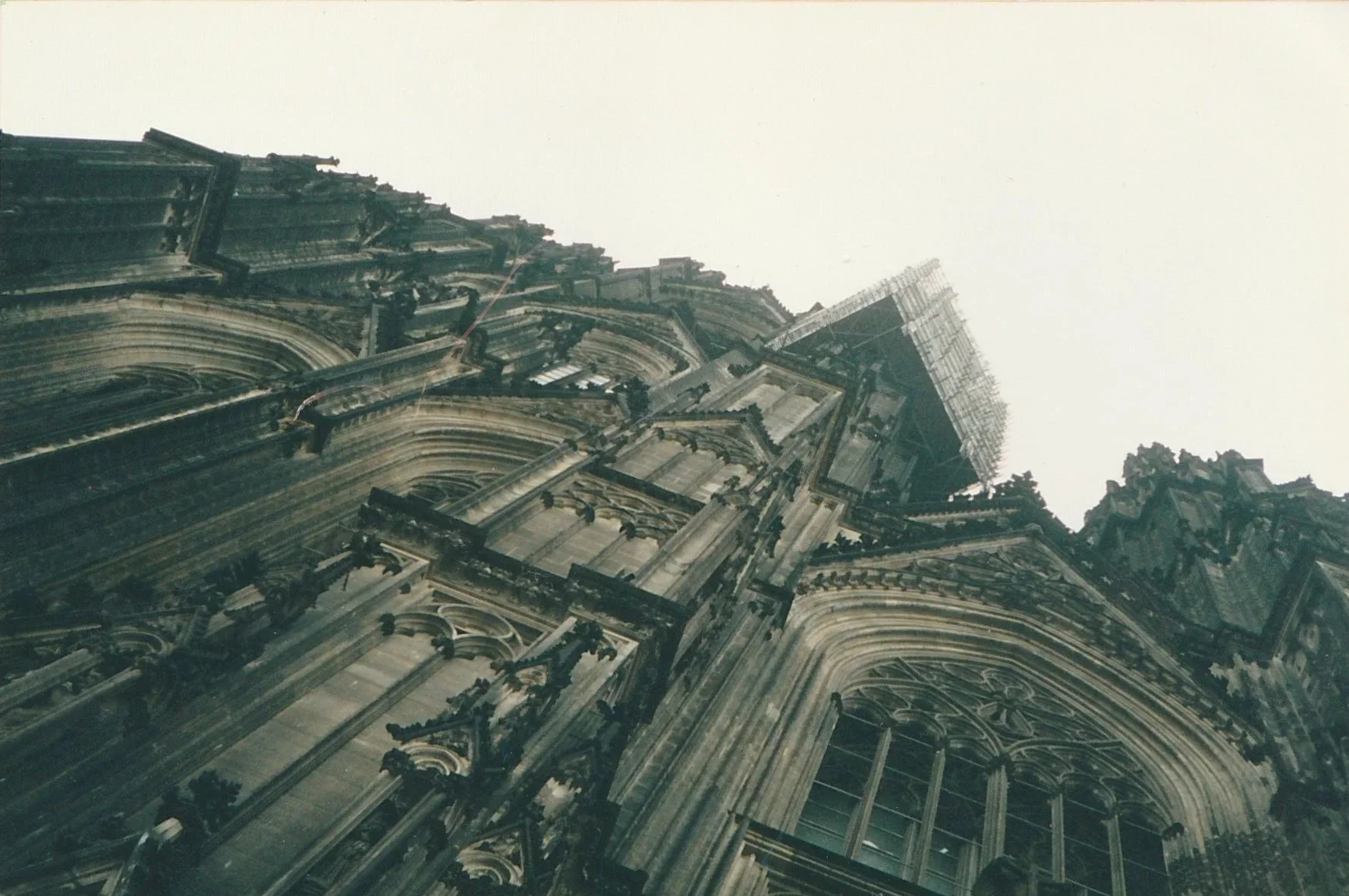 Tall Gothic church spire rising sharply against a bright sky.