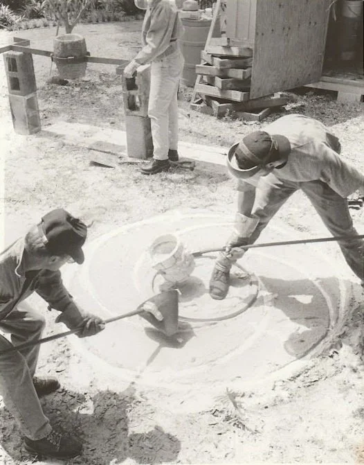 Whitney Wolf II and students pouring bronze into spiral markings in the ground in order to cast its shape.
