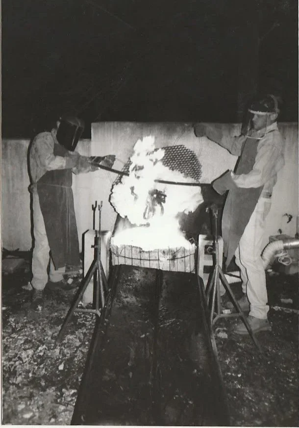 Whitney Wolf II teaching students to cast bronze. Black-and-white photo. EST 1980s