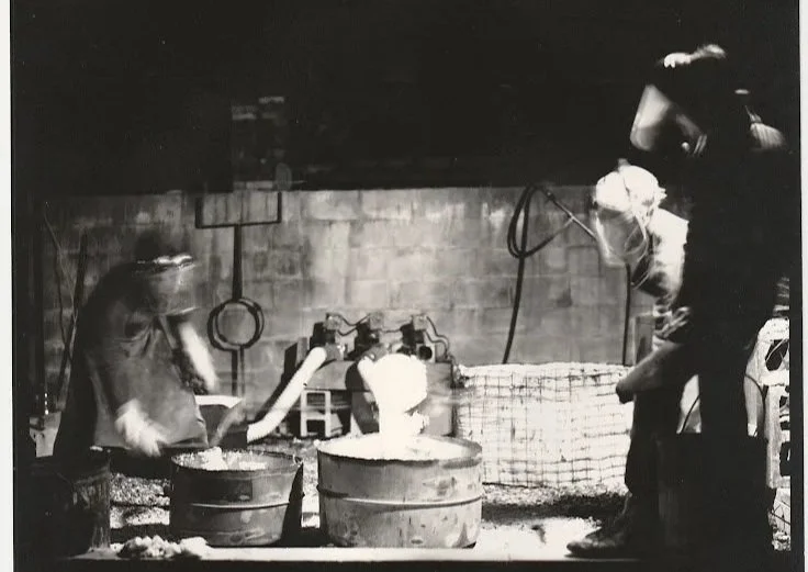 Whitney Wolf II teaching students to cast bronze. Black-and-white photo. EST 1980s