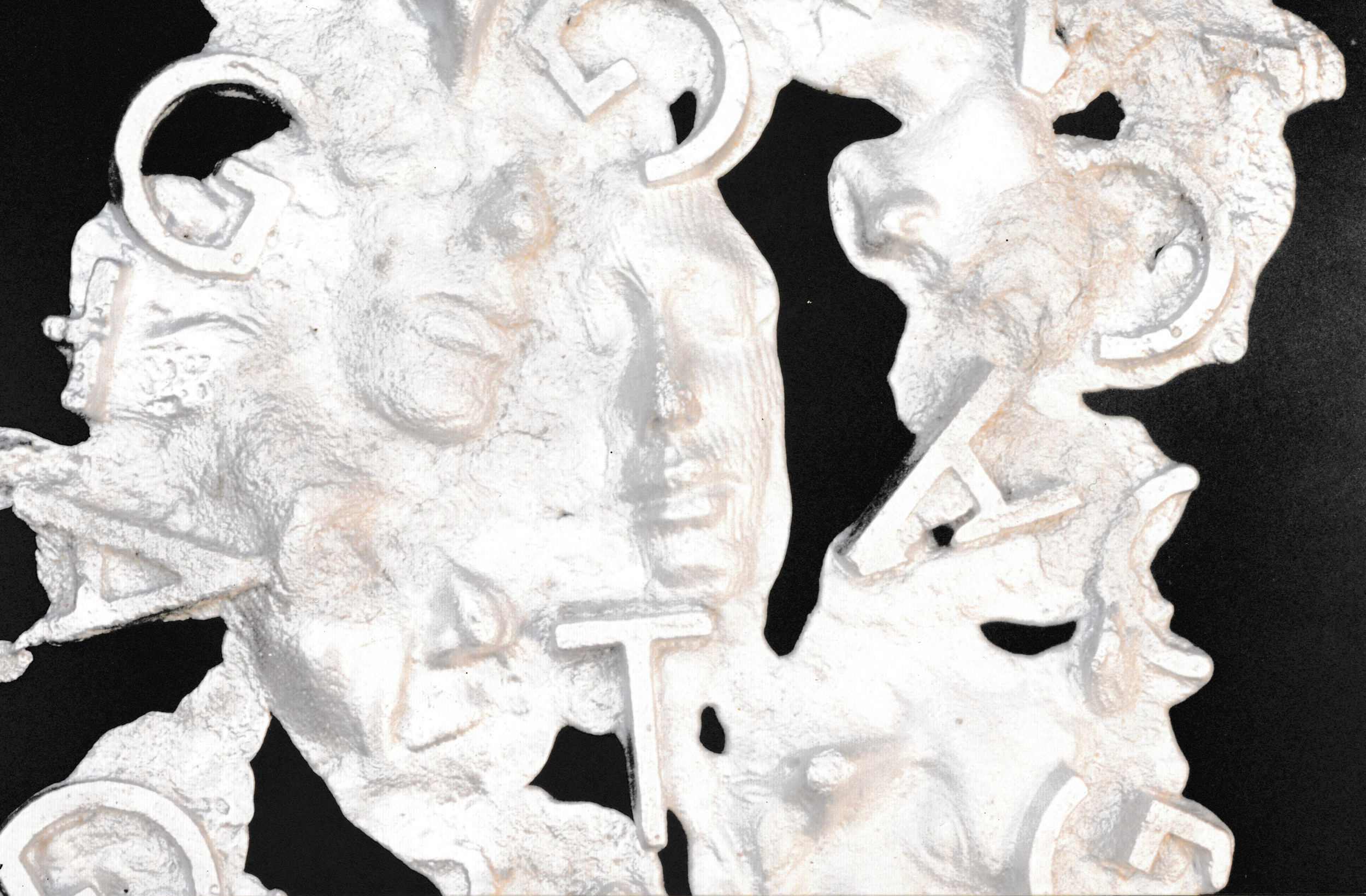 Close-up view of a textured white relief sculpture featuring facial forms and embedded letter shapes.
