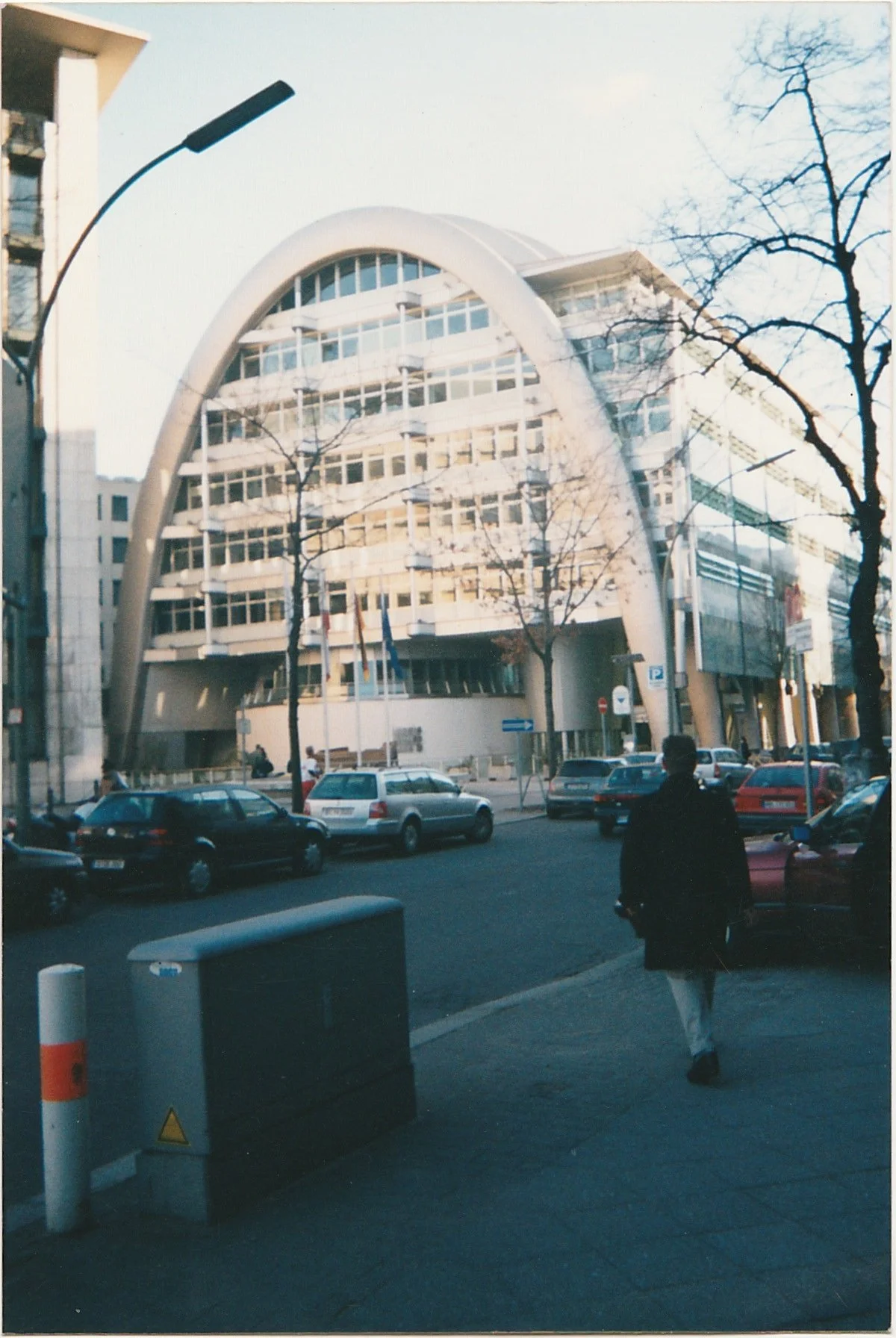 Modern office building framed by a large sculptural arch.
