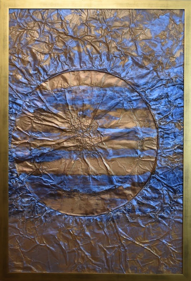 A luminous copper-toned sphere emerges through layers of deep blue and violet, resembling a distant planet suspended in a turbulent field of space and energy. Shown close up in a gold frame.