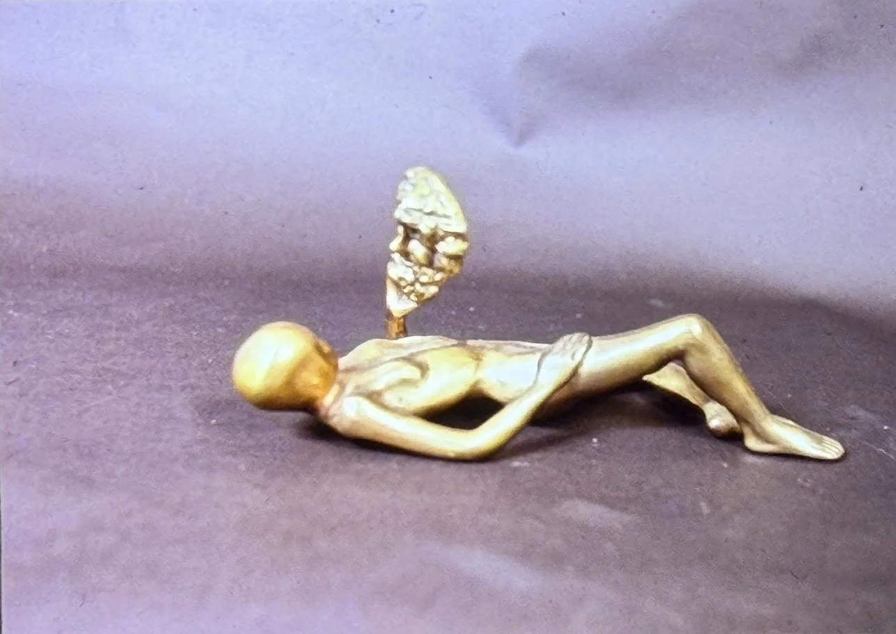 Surreal reclining bronze figure with detached head hovering above the torso, creating a dreamlike separation between body and identity.