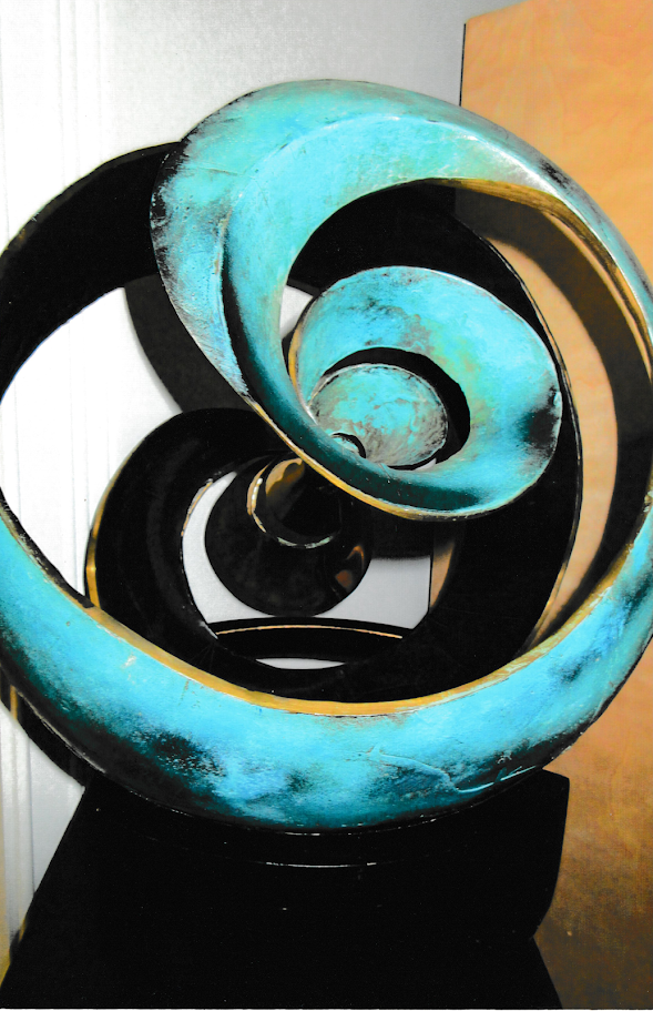 Close-up view of overlapping turquoise spiral forms curving inward toward a circular center, creating a tunnel-like effect.
