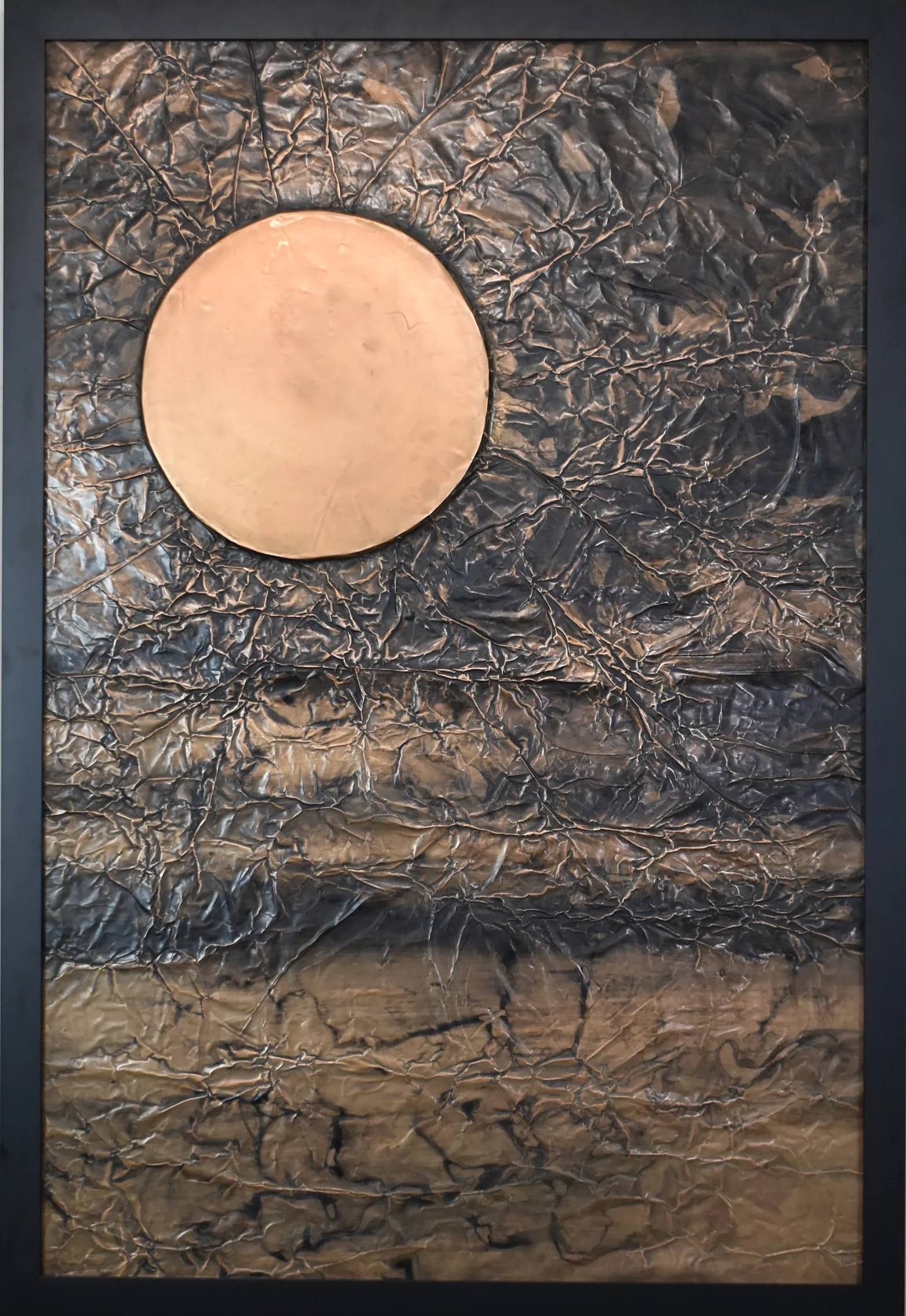 A golden orb floats within a dark, fractured metallic field. Shown close up in a black frame.