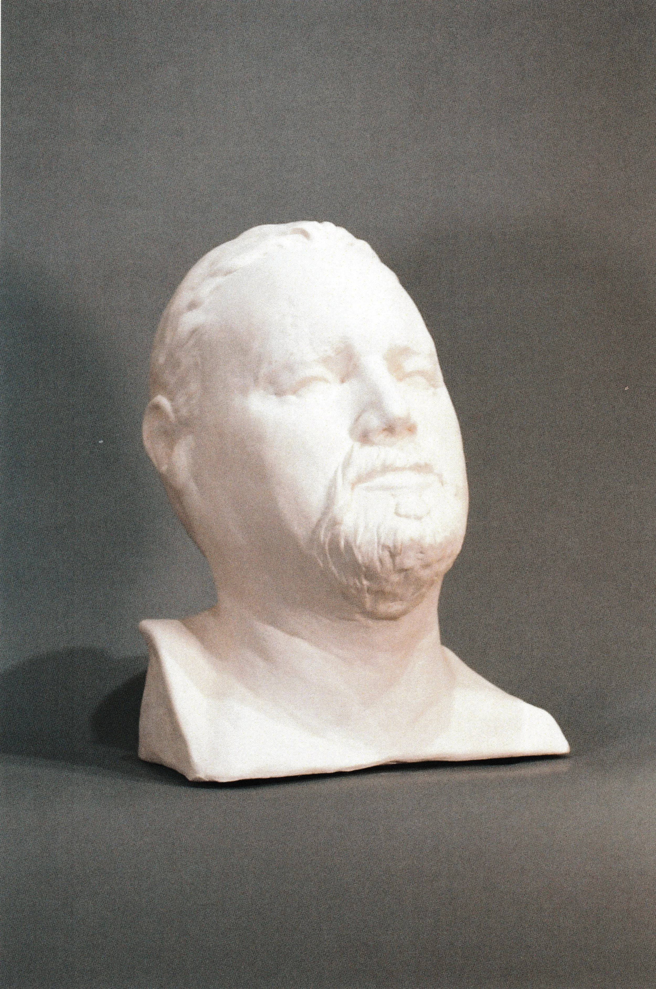 Ceramic life mask of a bearded man with closed eyes and uplifted head, expressing contemplation and reverence.