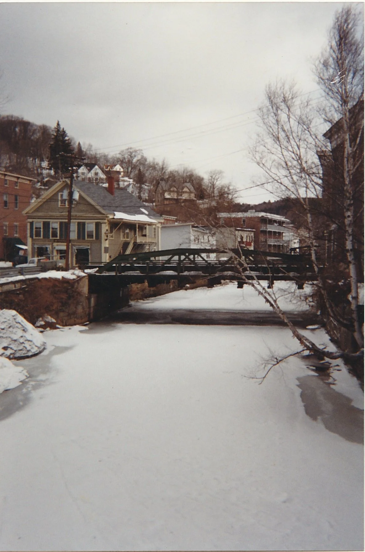 Snow-covered river winding through a winter town landscape.
