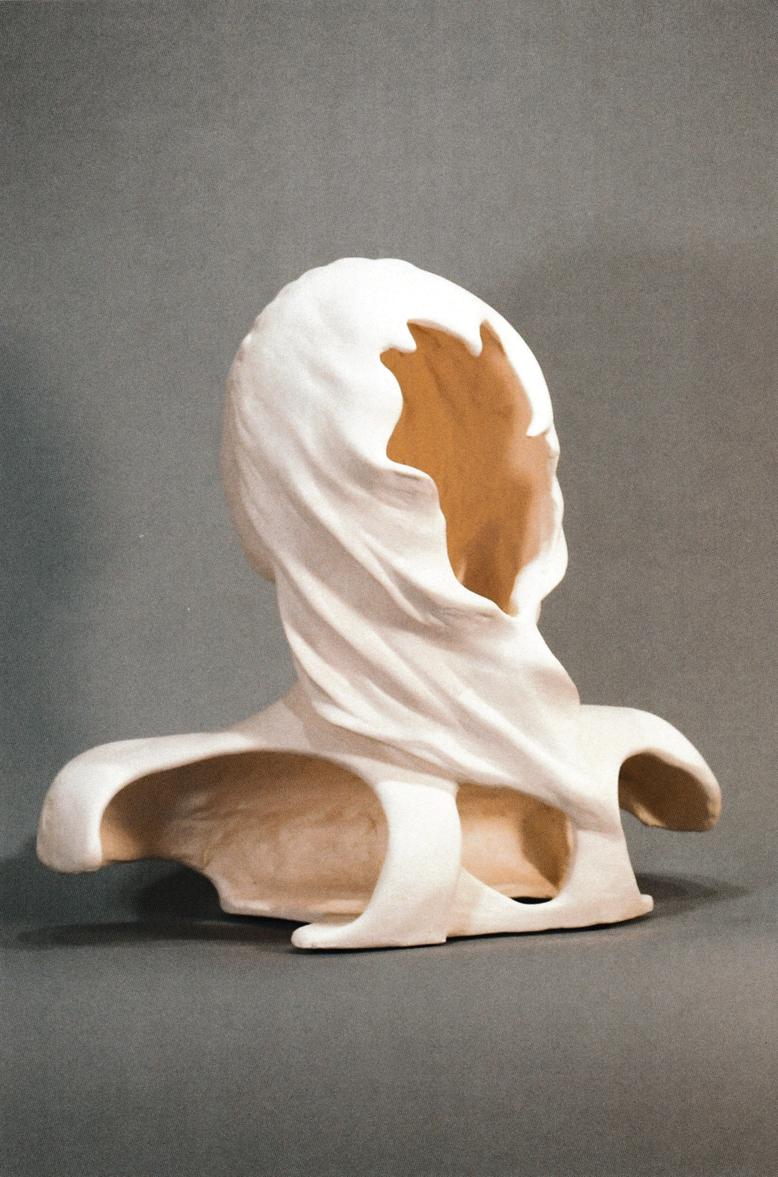 Back Side of the Ceramic life mask portrait with simplified features. There is an open and hollow flowing hole on the back of the head of this ceramic life mask. 