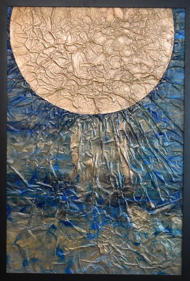 A pale orb radiates over turbulent blue currents. Shown close up in a black frame.