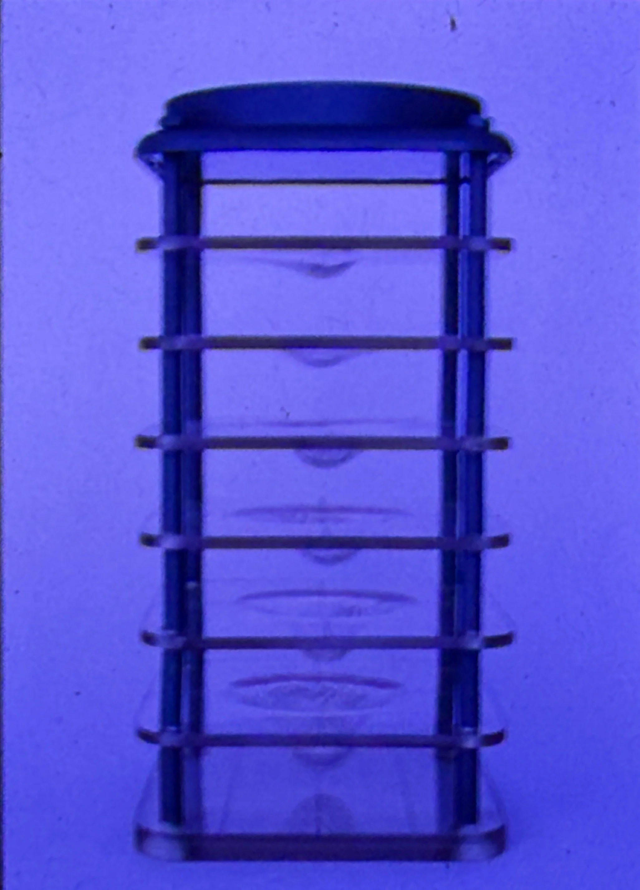 Vertical cylindrical structure composed of stacked transparent circular layers enclosed within a dark frame.
