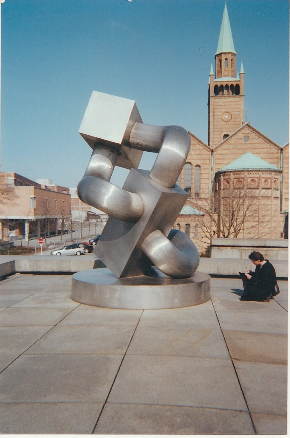 Large abstract metal sculpture displayed in an open public plaza.