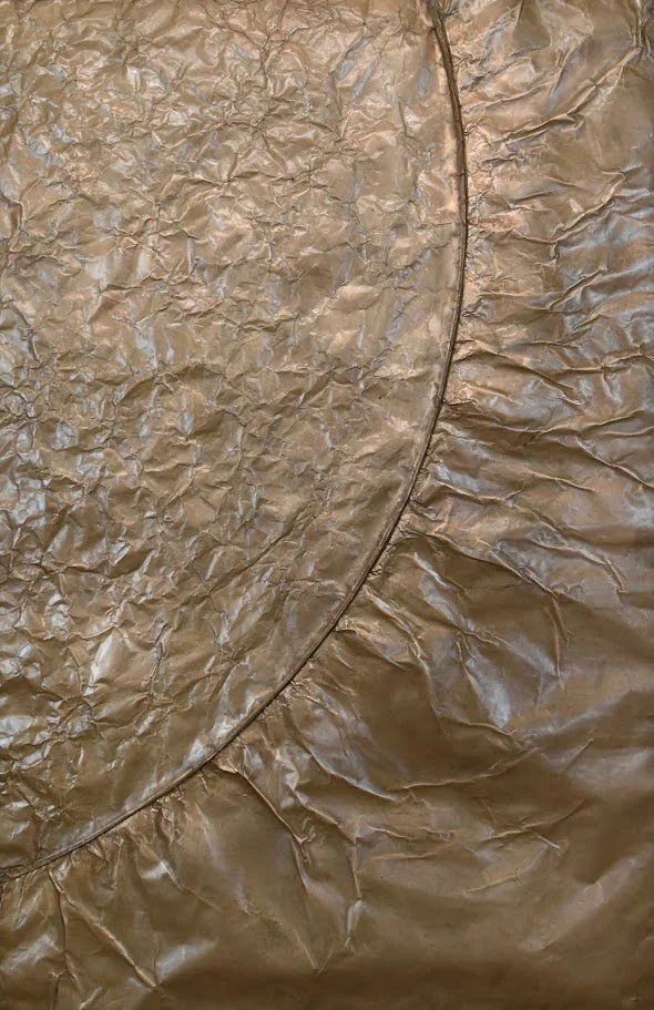 A sweeping golden arc divides contrasting metallic textures. Shown close up without a frame.