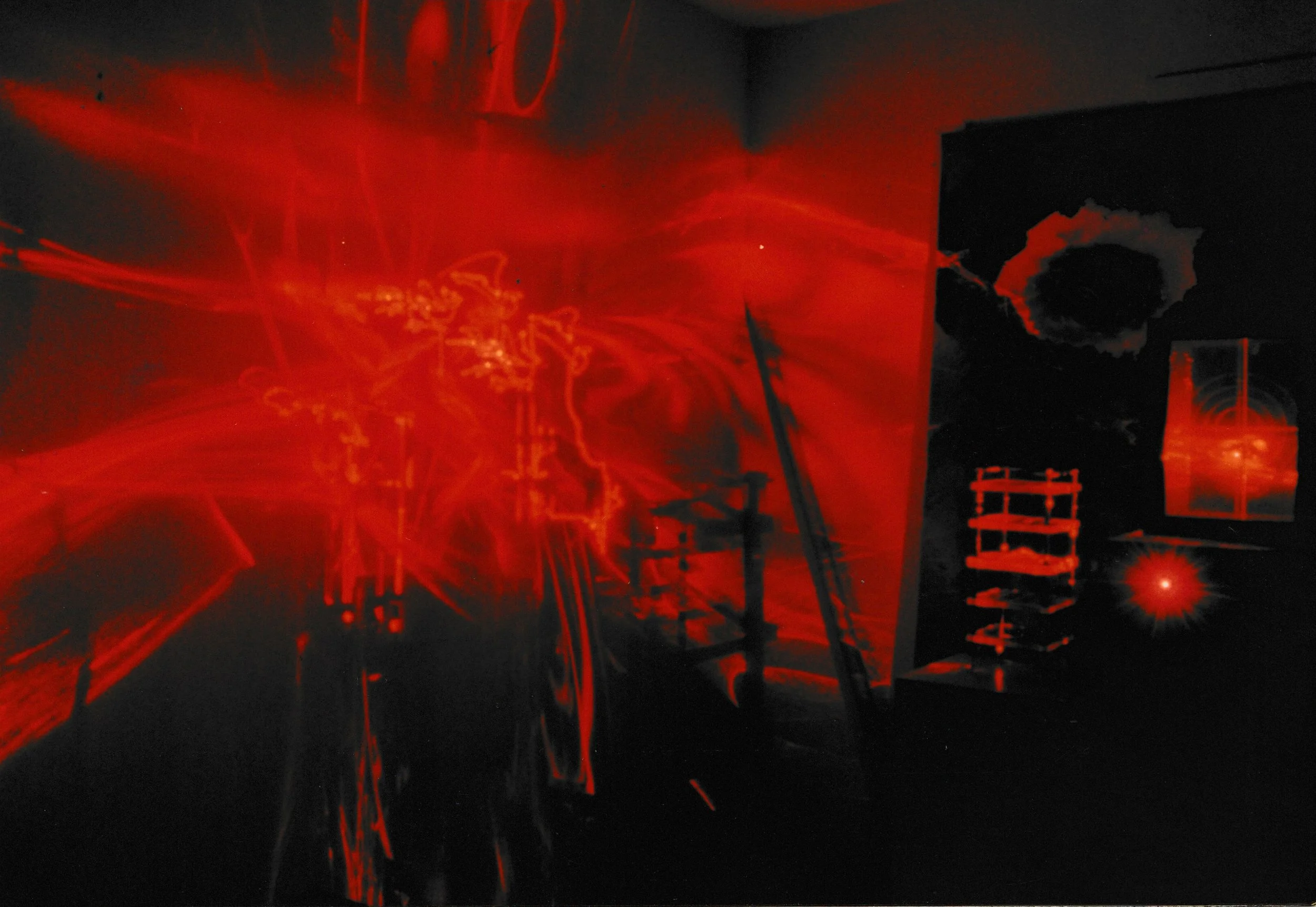 Abstract red laser composition featuring a glowing circular form surrounded by scattered light patterns.