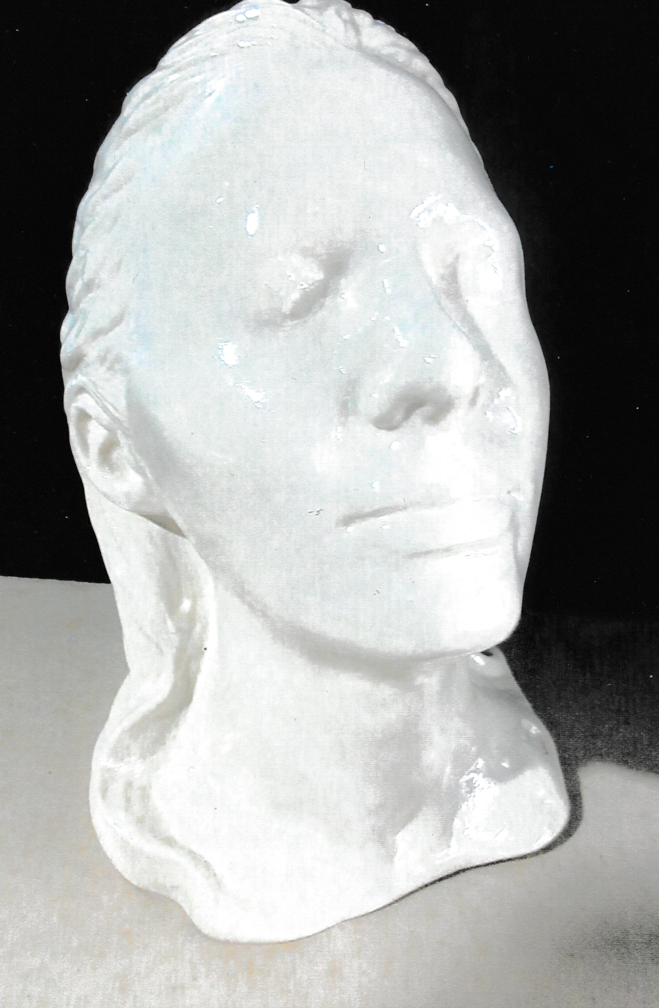 Three-quarter view of a ceramic life mask portrait with closed eyes and softly swept-back hair.