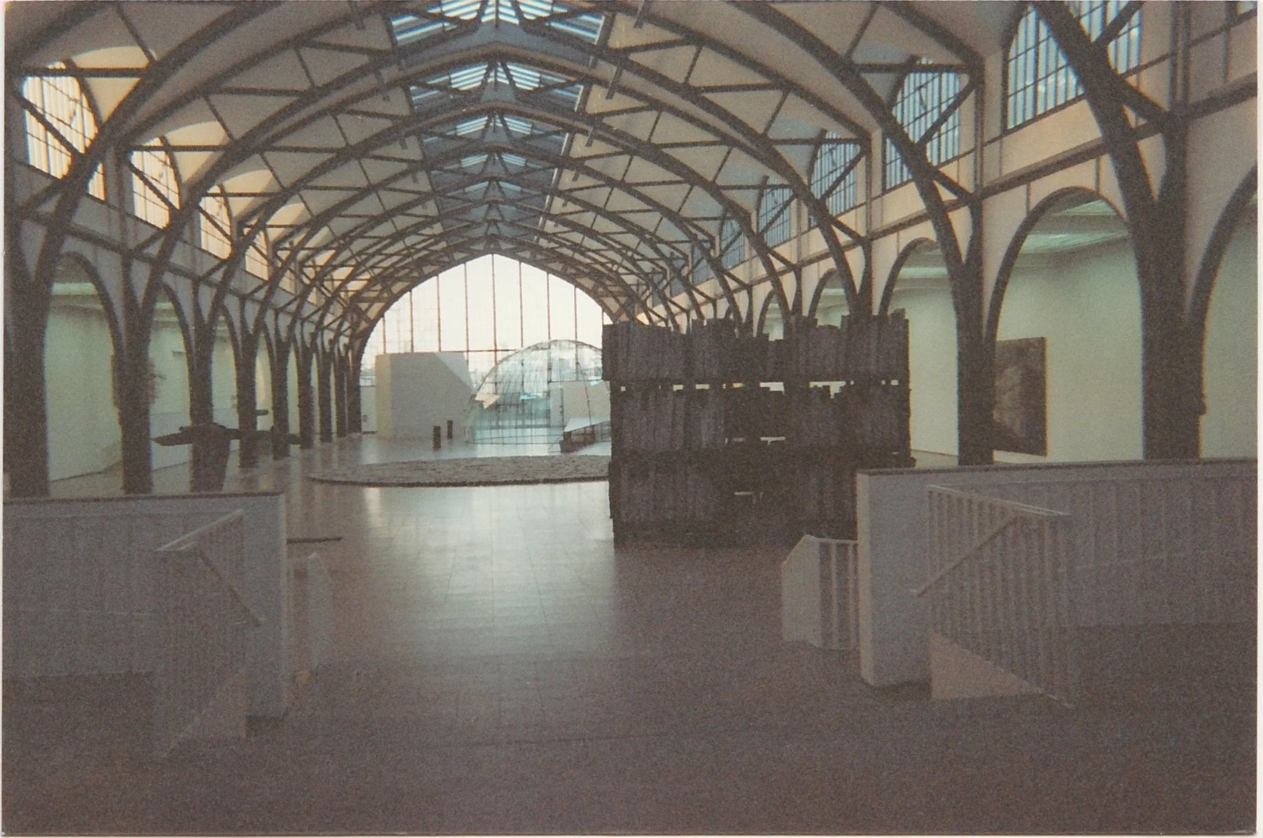 Covered pavilion with exposed timber framework and filtered natural light.