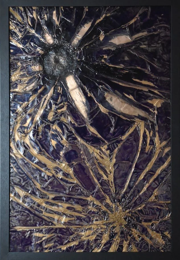 Radiating gold forms burst across a deep violet field. Shown close up in a black frame.