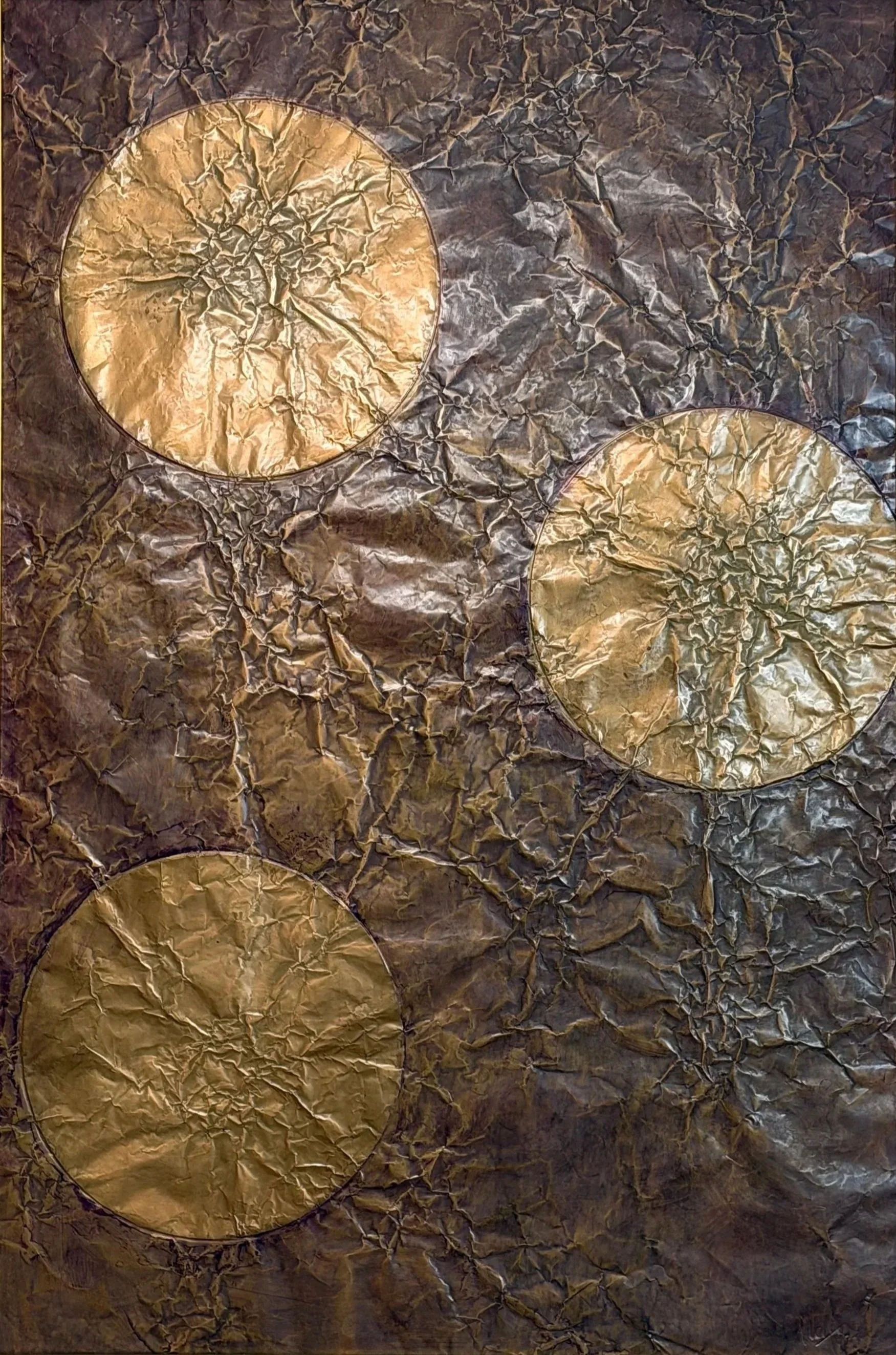 Three golden orbs float within a dark metallic field. Shown close up without a frame.