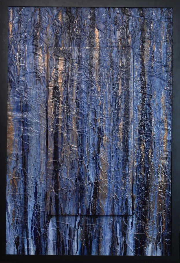 Vertical blue and black currents flow across a textured metallic field. Shown close up in a black frame.