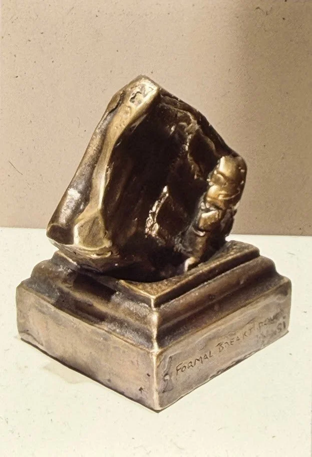 Abstract bronze form resting on a pedestal-like base. Angular planes and recessed surfaces create a faceted, architectural appearance.