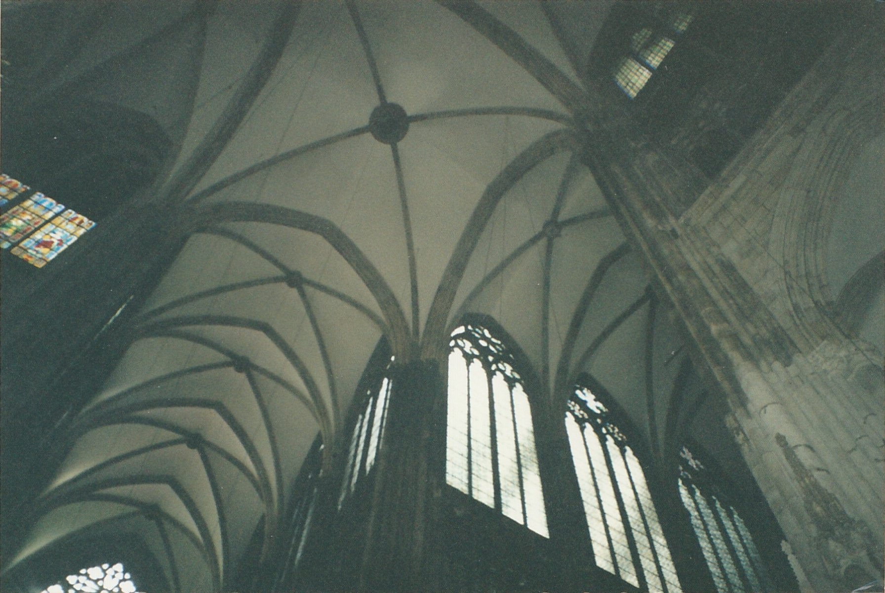 Gothic cathedral interior with vaulted ceilings and sunlight streaming through high windows.