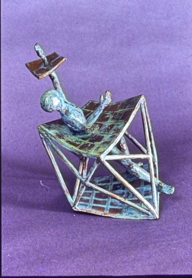 Abstract figurative sculpture of a reclining human form within an open geometric structure.