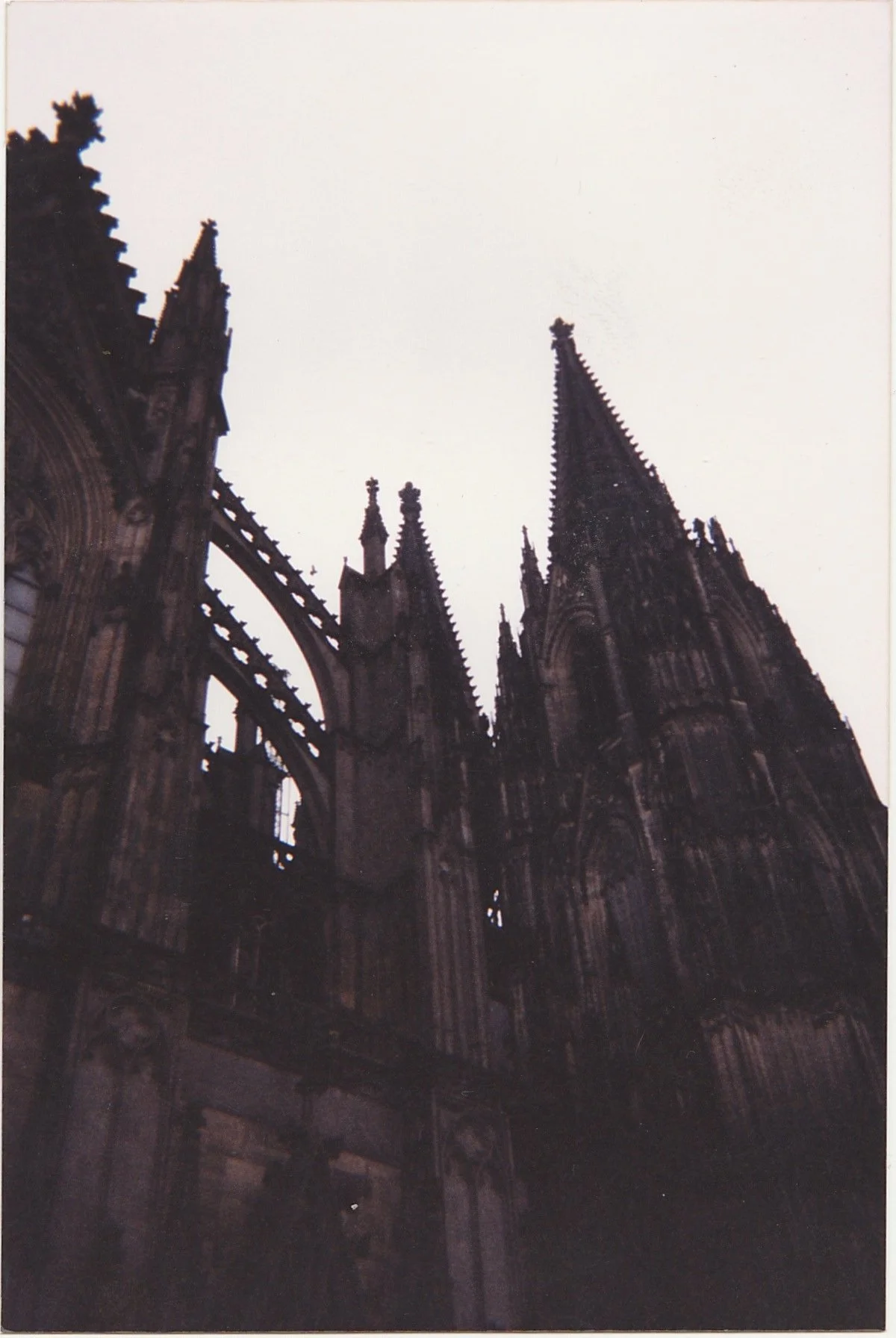 Gothic cathedral silhouette rising dramatically against a dark evening sky.