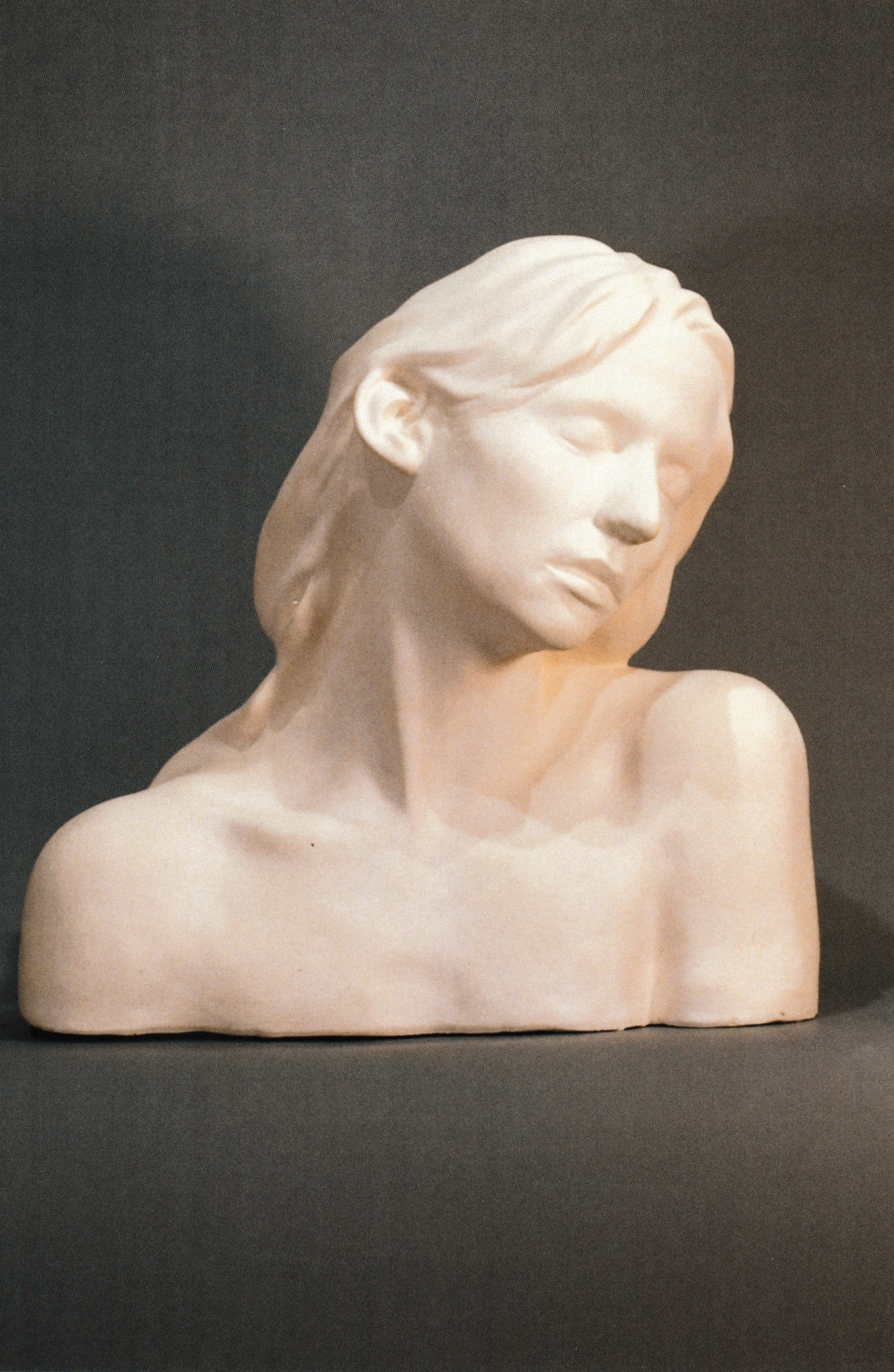 Ceramic life mask bust of a woman with head gently bowed and eyes closed, conveying a reflective, inward mood.