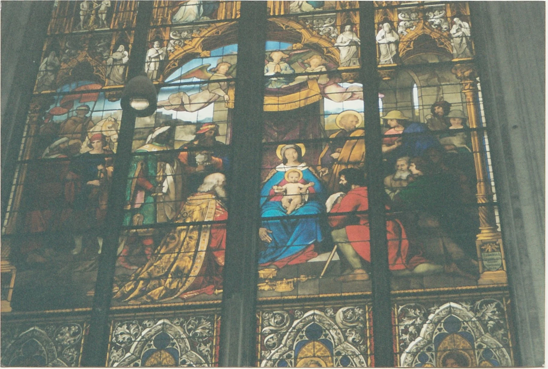 Stained-glass church window depicting religious figures in vivid colors.