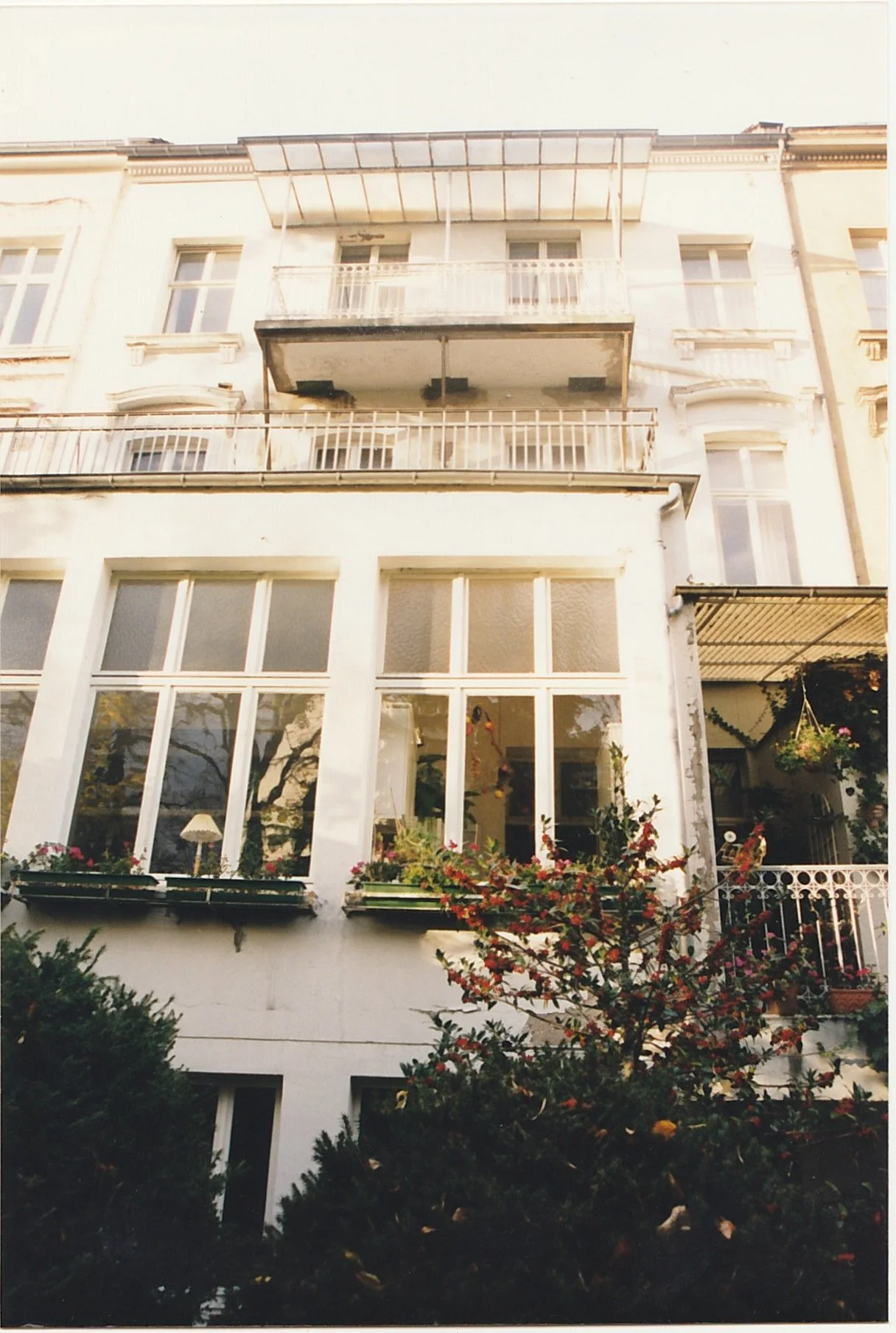Elegant townhouse with tall windows and landscaped front garden.
