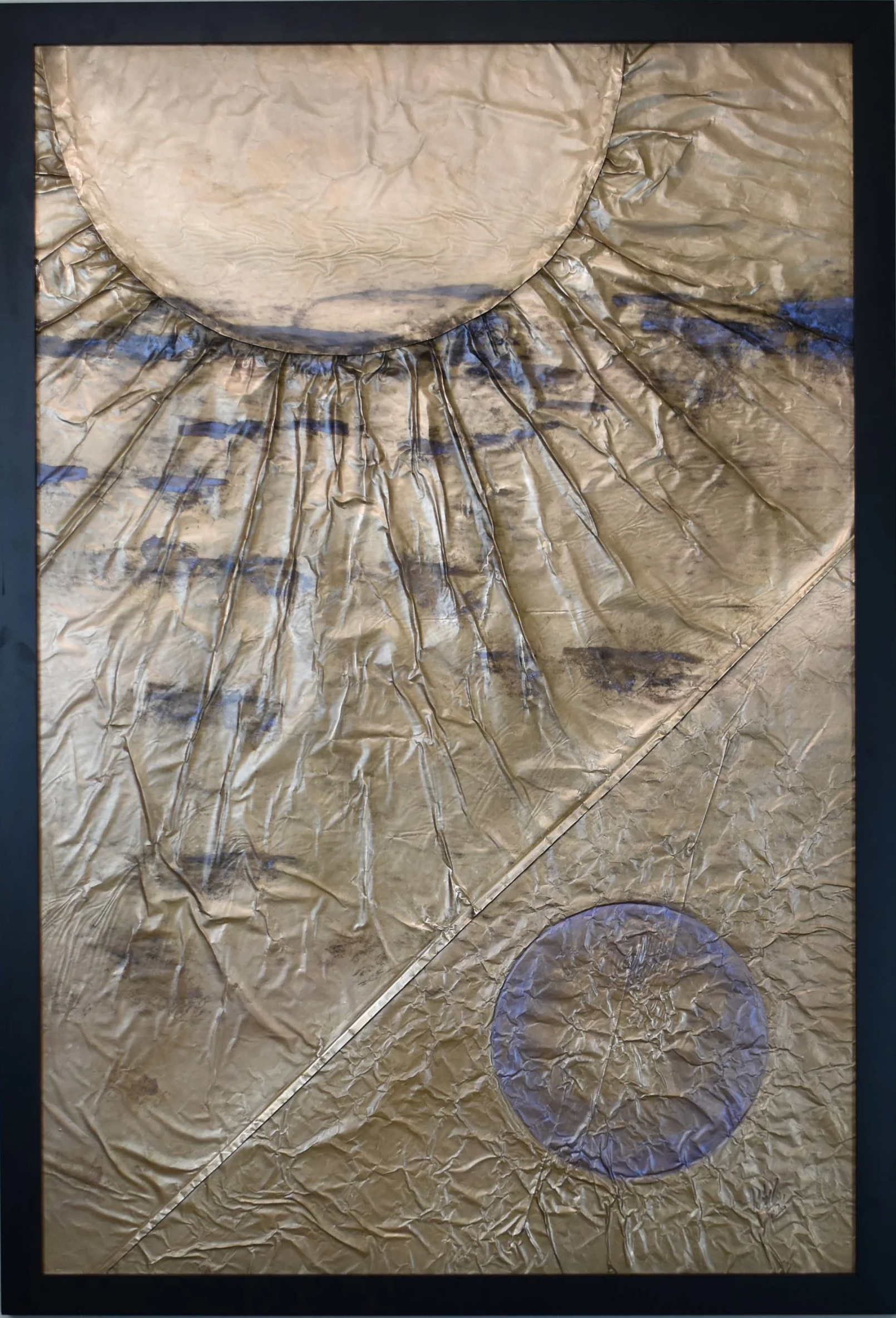 Textured gold-toned abstract artwork featuring a large circular form above, a smaller violet circle below, and radiating geometric lines. Shown close up in a black frame.