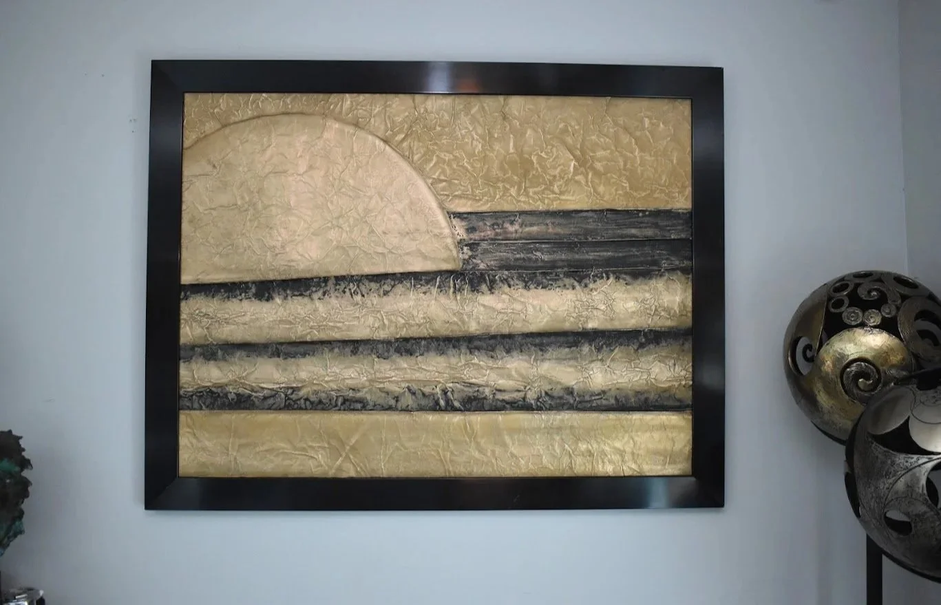 A golden orb rises above layered bands of black and metallic gold.